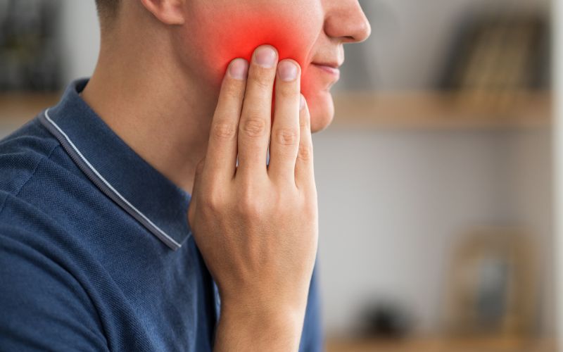 Ból i zaczerwienienie spowodowane odrzuceniem implanta zębowego.